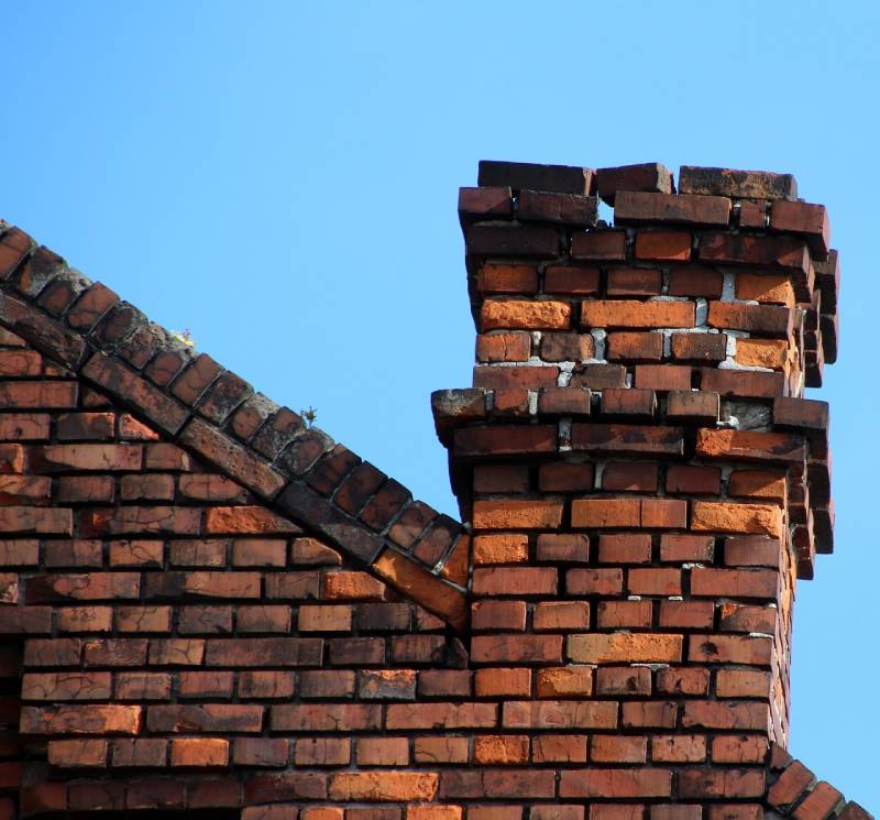 Damaged chimney on an Hinsdale home showing cracks and missing mortar